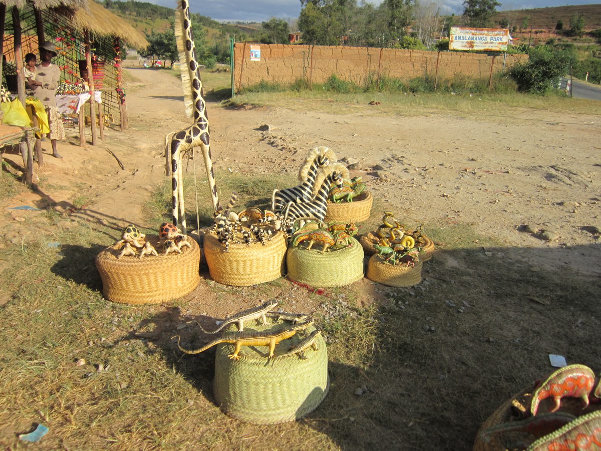 Madagaskar: Einkauf von Bastfiguren in einem Dorf auf der Straße von Tana nach Antsirabe. In dem Dorf stellt jed